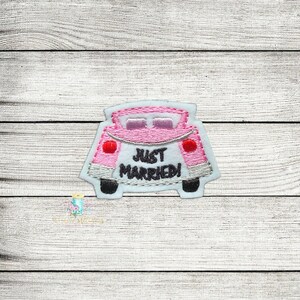 May include: Pink embroidered patch of a car with the text "Just Married!" on the back.