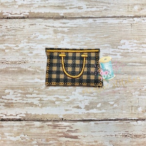 Op de afbeelding: Een kleine, zwart-wit geblokte draagtas met een gele handvat. De tas is gemaakt van stof en heeft een gestikt ontwerp.