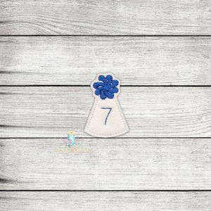 Peut inclure: Chapeau de fête en feutre blanc avec une fleur bleue sur le dessus et le chiffre 7 brodé sur le devant.