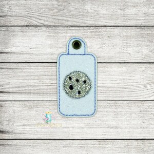 May include: A light blue key chain with a white and black cookie design.