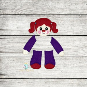 May include: Felt craft doll pieces for a girl doll. The doll has red hair, a purple dress, and red shoes. The pieces are ready to be sewn together.