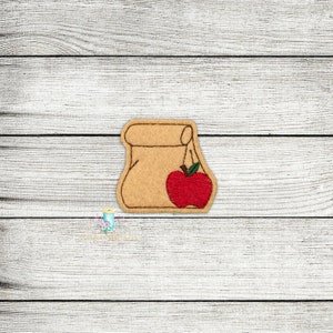 May include: A brown paper lunch bag with a red apple on the front. The apple has a green stem and leaf.
