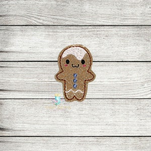 May include: A brown gingerbread man with a white icing smile and a blue icing button. The gingerbread man is embroidered on a white fabric background.