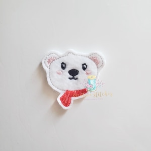 May include: White polar bear with black eyes and a red scarf. The bear is embroidered on a white fabric.