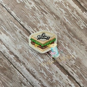 May include: A beige felt patch with an embroidered image of a sandwich with the text "Our Special" above it.