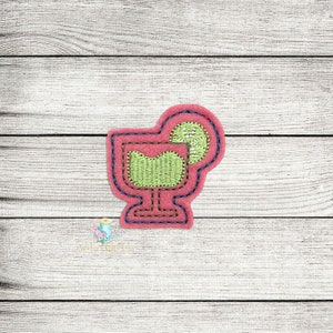 May include: An embroidered patch depicting a margarita glass with a lime wedge, in pink and green colours.