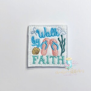 May include: Embroidered patch with the text "Walk by Faith" in blue and green thread. The patch features a pair of pink flip flops, a seashell, and seaweed.