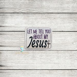 May include: A white rectangular patch with a stitched border. The text "Let me tell you about my Jesus+ " is embroidered in black with a purple outline.