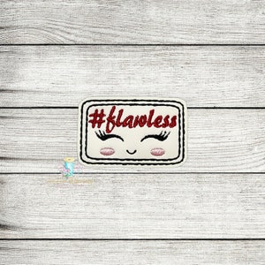 Puede incluir: Un parche blanco bordado con un borde negro y texto rojo que dice "#flawless". El parche tiene una cara de dibujos animados con pestañas y mejillas rosadas.