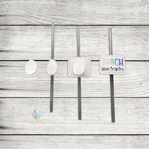 May include: Three grey straws with white felt embellishments. The first straw has a plain circle, the second has an oval, and the third has a square with the text "TEACH love inspire" in rainbow colours.