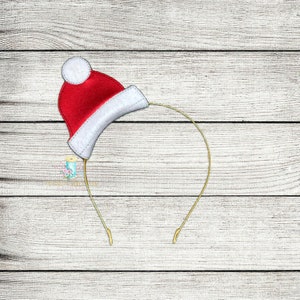 May include: A red and white felt Santa hat headband. The headband is gold and the hat has a white pom pom on top.