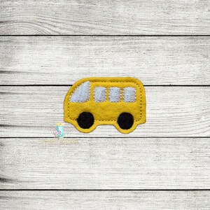 May include: A yellow felt school bus applique with white windows and black wheels.