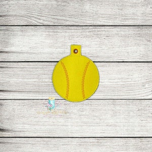 May include: A yellow softball-shaped keychain with orange stitching details. The keychain has a small loop at the top for attachment. The design mimics the look of a softball, perfect for sports enthusiasts.
