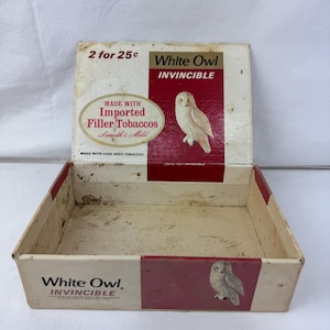 Könnte beinhalten: Vintage White Owl Invincible Zigarrenkiste. Die Box ist weiß mit roten Akzenten und zeigt eine Eulenillustration. Der Text auf der Box lautet "2 for 25c", "Made with Imported Filler Tobaccos" und "Invincible".