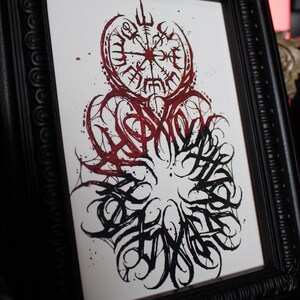 May include: A framed black and white print with a red and black design. The design features a compass with a circle of runes around it. The word "SPIRIT" is written in a stylized font around the compass.