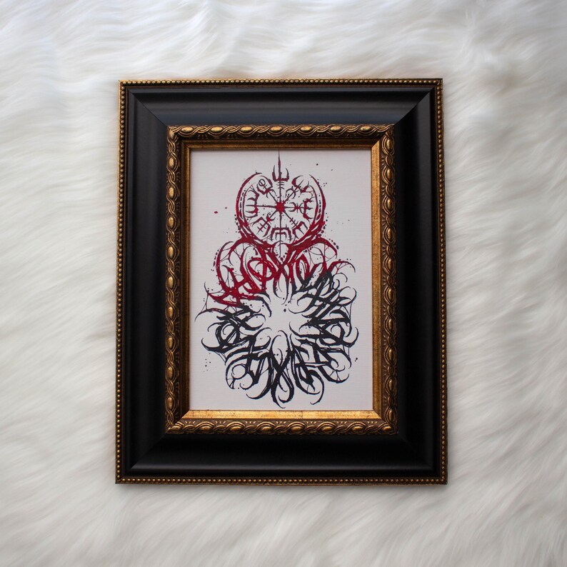 May include: A framed print with a black and red design. The design features a compass with a circle of text around it. The text is in a stylized font and is difficult to read.