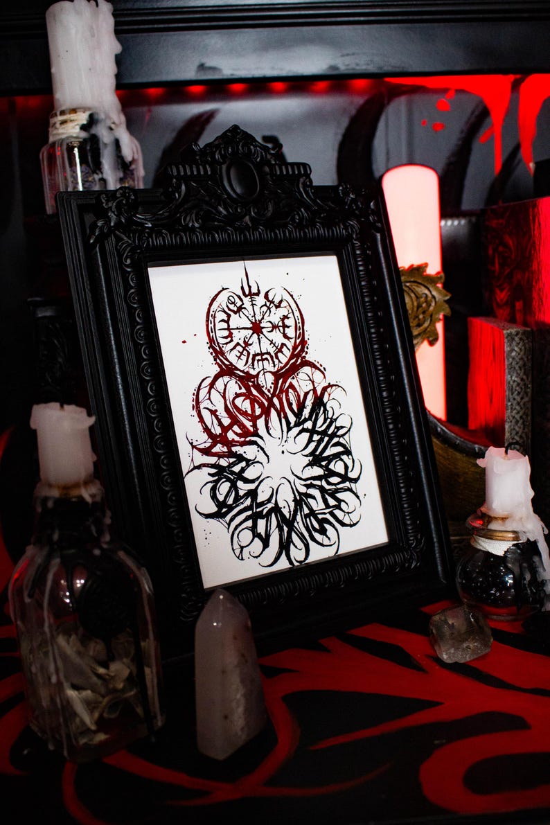 May include: A black framed print with a white background and a black and red design. The design features a compass with runes and a circle of stylized text.