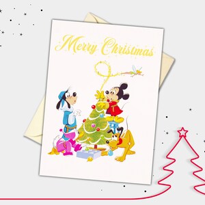 May include: A Christmas card featuring Mickey Mouse, Goofy, and Pluto decorating a Christmas tree. The card has the text "Merry Christmas" in gold lettering.