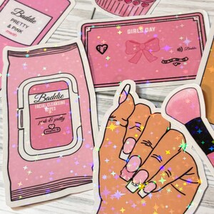 May include: Pink and white holographic stickers with glitter. The stickers feature a makeup brush, a hand with long nails, a bottle of pink liquid with the text "Baddie Pretty & Pink mwah", and a pink card with the text "Girls Day" and a pink bow.