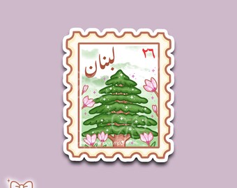 May include: A sticker featuring a green pine tree with white accents, pink flowers, and the Arabic word "Lebanon" in a stamp design. The sticker has a scalloped border and the number 26 in the upper right corner.