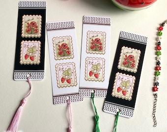 May include: Four decorative bookmarks with tassel accents. Two bookmarks are black with white zigzag borders, and two are white with burgundy zigzag borders. Each bookmark features two postage stamp designs with red flowers and strawberries.