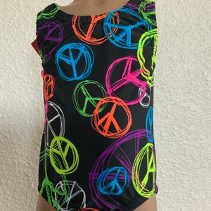 May include: Black leotard with a colorful peace sign pattern. The leotard has a scoop neck and a sleeveless design.