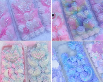 May include: A collection of phone cases decorated with textured, piped cream-like material in pastel colors. The cases feature various resin charms including stars, moons, hearts, and wings, with some displaying text like "SPOILED BRAT" and "G PRO GROUPIE".