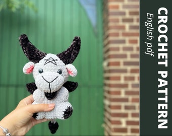 May include: Crochet pattern for a gray and black amigurumi goat with a pentagram on its forehead. The pattern is available as a digital download in English.