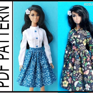 Könnte beinhalten: Zwei Puppen, die verschiedene Outfits tragen. Die Puppe links trägt eine weiße Bluse mit langen Ärmeln, blauen Knöpfen und einem blauen Blumenrock. Die Puppe rechts trägt ein langärmeliges Blumenkleid mit schwarzem Hintergrund. Beide Puppen haben schwarzes Haar und tragen Blumenhaarspangen.