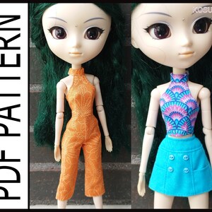 May include: Two doll outfits, one is a bright orange jumpsuit with a floral pattern, the other is a blue skirt with a patterned top in shades of pink, blue, and white.