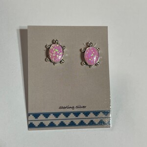 May include: A pair of sterling silver earrings featuring a pink opal turtle design.