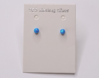 May include: A pair of blue opal stud earrings on a white card with the text "925 sterling silver".