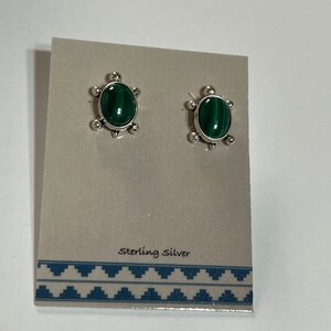 May include: A pair of sterling silver earrings with green malachite stones. The earrings are on a white card with the text "Sterling Silver".