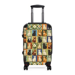 May include: A rolling suitcase with a black handle and wheels. The suitcase is covered in a colorful pattern of cats in various poses and colors, set against a backdrop of floral and geometric designs. The cats are in squares of different colors.