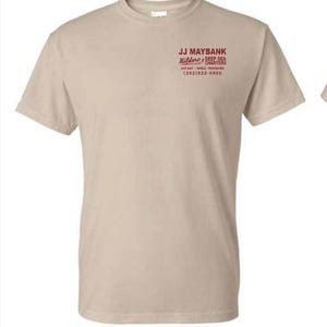 May include: A beige short-sleeved t-shirt featuring red text on the upper left chest that reads JJ MAYBANK, Kildare Island DEEP SEA CHARTERS, LIVE BAIT TACKLE PROVISIONS, and the phone number (252) 522-5502 in a clean, sans-serif font style.