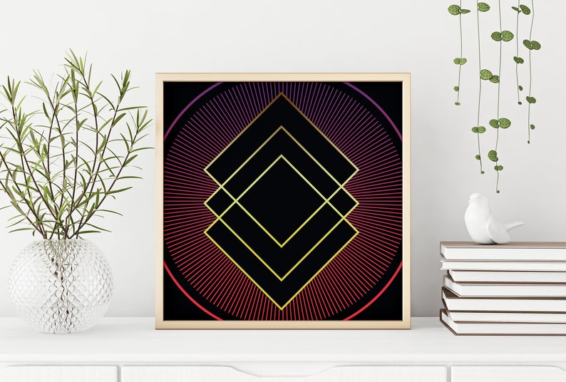 May include: A framed geometric print with a black background and a gold diamond shape in the center. The diamond is surrounded by a circle of red and purple lines radiating outward.