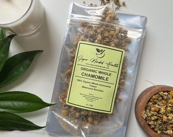 Könnte beinhalten: Ein transparenter Plastikbeutel gefüllt mit getrockneten Kamillenblüten. Der Beutel trägt ein Etikett mit der Aufschrift "Super Minded Health" und "Organic Whole Chamomile". Das Etikett enthält auch den Text "100% Organic Whole Chamomile Flower (Matricaria Recutita)".