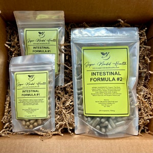 Puede incluir: Tres bolsas de pl&aacute;stico transparente llenas de c&aacute;psulas verdes etiquetadas con "Super Minded Health" y "Intestinal Formula #1" y "Intestinal Formula #2". Las bolsas est&aacute;n en una caja llena de papel marr&oacute;n triturado.