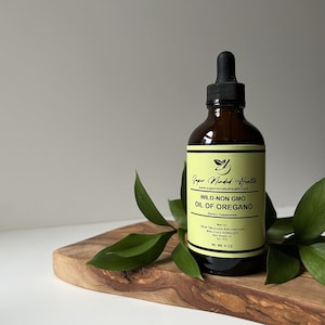 May include: A 4 ounce amber glass bottle with a dropper top filled with a yellow liquid. The bottle label is yellow with black text that reads "Super Minded Health", "www.supermindedhealth.com", "WILD-NON GMO", "OIL OF OREGANO", "Dietary Supplement", "Made by", "NEW ORLEANS APOTHECARY", "WHOLESALE HERBALISTS", "New Orleans, LA", "Est. 1979", and "NET. Wt. 4 OZ".