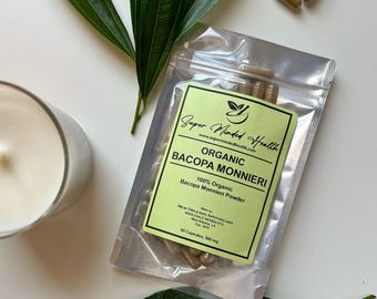 May include: A silver pouch with a green label that reads "Super Minded Health" and "Organic Bacopa Monnieri" with 50 capsules inside. The pouch is on a white surface with green leaves.