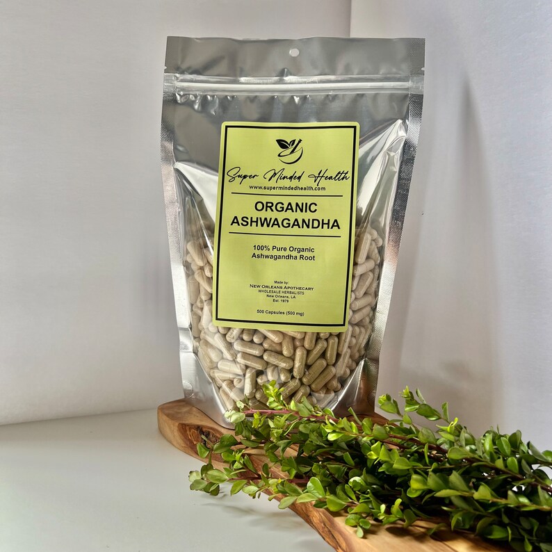May include: A silver resealable bag filled with beige capsules labeled "Organic Ashwagandha 100% Pure Organic Ashwagandha Root" with the brand name "Super Minded Health" and website address "www.supermindedhealth.com".