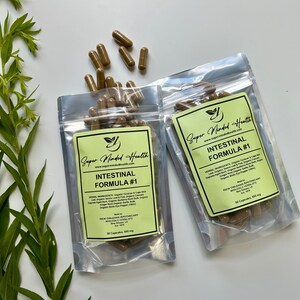 Puede incluir: Dos bolsas de pl&aacute;stico transparentes con etiquetas verdes que contienen c&aacute;psulas marrones. Las etiquetas dicen "Super Minded Health" y "Intestinal Formula #1". Las bolsas contienen 50 c&aacute;psulas de 550 mg cada una.