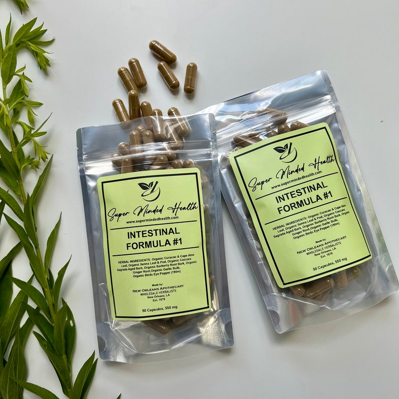 Puede incluir: Dos bolsas de pl&aacute;stico transparentes con etiquetas verdes que contienen c&aacute;psulas marrones. Las etiquetas dicen "Super Minded Health" y "Intestinal Formula #1". Las bolsas contienen 50 c&aacute;psulas de 550 mg cada una.