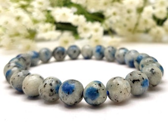 May include: A blue and white kyanite beaded bracelet. The beads are round and have a speckled pattern.