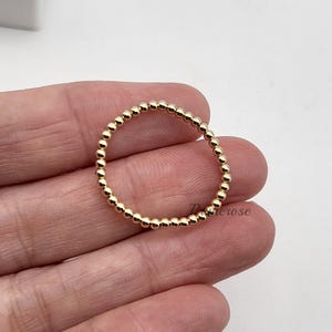 May include: A gold beaded ring with a simple design. The ring is made of small, round beads that are evenly spaced.