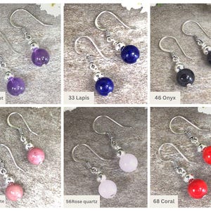 May include: A set of ten pairs of silver dangle earrings with various gemstone beads. The beads are amethyst, lapis lazuli, onyx, rhodonite, rose quartz, and coral.