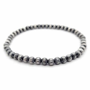 May include: A silver beaded bracelet with a ribbed texture on each bead.