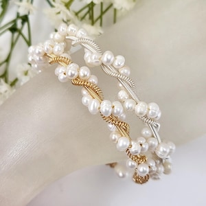 May include: Two delicate bracelets made with white pearls and twisted wire. One bracelet is gold and the other is silver.