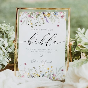 May include: A gold-framed sign with a floral design and the text "PLEASE SIGN OUR bible Highlight your favorite verse and write us a note ♡ Olivia & David"