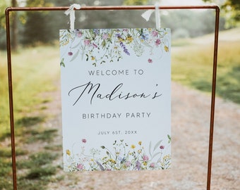 Könnte beinhalten: Ein weißes Schild mit floralem Rand und dem Text "Welcome to Madison's Birthday Party July 6st, 20XX" steht auf einem Kupferständer in einem grasbewachsenen Bereich.